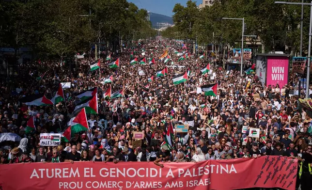 Demonstrators hold a banner with writing reading in Catalan "Let’s stop the genocide in Palestine, no more arms trade with Israel”" during a pro-Palestinian rally in solidarity with the Global Sumud Flotilla after ships were intercepted by the Israeli navy, in Barcelona, Spain, Saturday, Oct. 4, 2025. (AP Photo/Emilio Morenatti)
