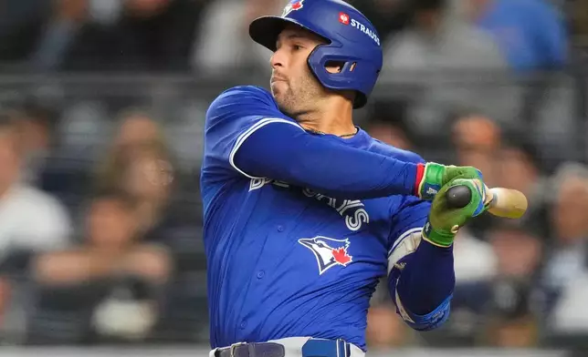Toronto Blue Jays right fielder George Springer follows through on a sacrifice fly ball that allowed Ernie Clement to score against the New York Yankees during the fifth inning of Game 4 of baseball's American League Division Series, Wednesday, Oct. 8, 2025, in New York. (AP Photo/Yuki Iwamura)