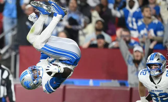 Detroit Lions wide receiver Jameson Williams (1) scores as teammate tight end Ross Dwelley (82) watches during the second half of an NFL football game against the Washington Commanders Sunday, Nov. 9, 2025, in Landover, Md. (AP Photo/Nick Wass)