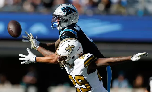 New Orleans Saints cornerback Quincy Riley breaks up a pass intended for Carolina Panthers wide receiver Tetairoa McMillan during the first half of an NFL football game, Sunday, Nov. 9, 2025, in Charlotte, N.C. (AP Photo/Rusty Jones)