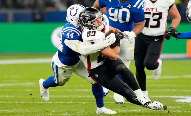 Atlanta Falcons tight end Charlie Woerner (89) is tackled by Indianapolis Colts linebacker Zaire Franklin (44) after catching a pass during the first half of an NFL football game, Sunday, Nov. 9, 2025, in Berlin, Germany. (AP Photo/Martin Meissner)