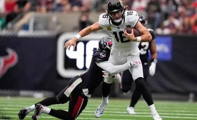 Houston Texans cornerback Tremon Smith (11) tackles Jacksonville Jaguars quarterback Trevor Lawrence (16) during an NFL football game, Sunday, Nov. 9, 2025, in Houston. (AP Photo/Ashley Landis)
