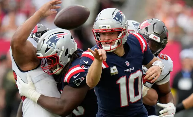 New England Patriots quarterback Drake Maye (10) throws a lateral pass against the Tampa Bay Buccaneers during the first half of an NFL football game Sunday, Nov. 9, 2025, in Tampa, Fla. (AP Photo/Chris O'Meara)
