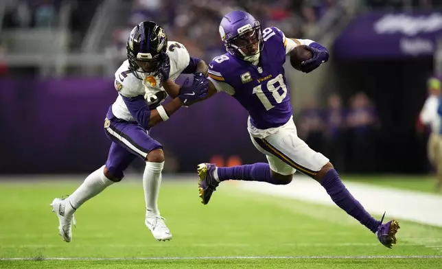 Minnesota Vikings wide receiver Justin Jefferson (18) carries for a first down against Baltimore Ravens cornerback Nate Wiggins (2) in the second half of an NFL football game, Sunday, Nov. 9, 2025, in Minneapolis. (AP Photo/Abbie Parr)