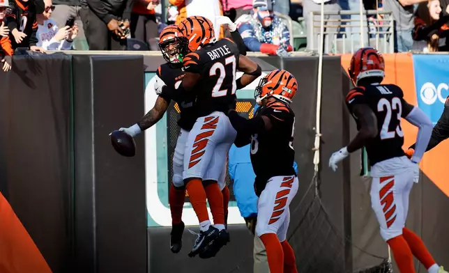 Cincinnati Bengals safety Geno Stone, left, celebrates with teammates after returning an interception for a touchdown during the first half of an NFL football game against the New England Patriots, Sunday, Nov. 23, 2025, in Cincinnati. (AP Photo/Jay LaPrete)