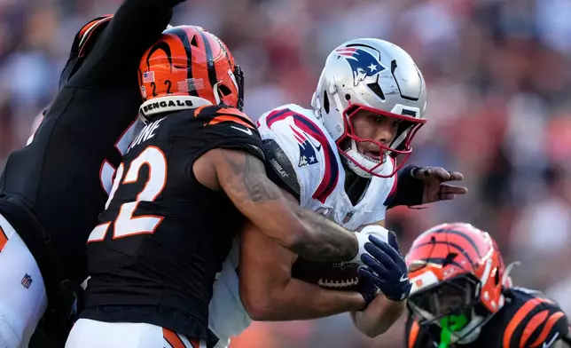 New England Patriots tight end Hunter Henry is tackled by Cincinnati Bengals safety Geno Stone (22) after catching a pass during the second half of an NFL football game, Sunday, Nov. 23, 2025, in Cincinnati. (AP Photo/Carolyn Kaster)