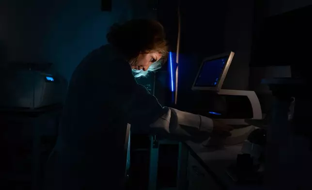 Dr. Mariana Kaplan, a rheumatologist and autoimmunity researcher, poses for a portrait working with a cell sample on a microscope in her lab at the National Institutes of Health, Monday, Aug. 25, 2025, in Bethesda, Md. Kaplan is an NIH Distinguished Investigator who leads research on systemic autoimmune diseases at the National Institute of Arthritis and Musculoskeletal and Skin Diseases. Kaplan's path to a career trying to unravel autoimmune diseases began while she was a doctor-in-training and helped care for young women severely ill with lupus, including one who died, at a time when there were fewer treatments. "No matter what I did, the diseases just progressed. I felt so impotent and frustrated about it, and so sad for them. The immune system in general fascinated me but this concept of autoimmunity and losing tolerance to yourself – what was causing this?" (AP Photo/David Goldman)