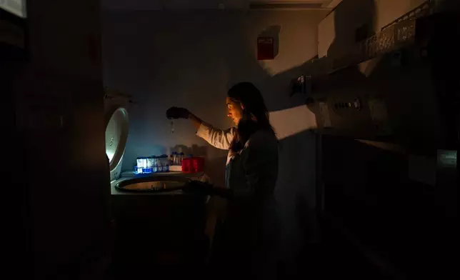 Dr. Laura Lewandowski, a pediatric rheumatologist and assistant clinical investigator, poses for a portrait at a centrifuge with tubes containing patient samples for autoimmunity testing in the lab where she works at the National Institutes of Health, Monday, Aug. 25, 2025, in Bethesda, Md. Lewandowski leads a team studying the genetics of pediatric lupus. "I've always been a person who loves puzzles and problem solving and the big picture of how people get sick. What I'm explaining to my family is that I'm a gene hunter. I could do back flips, inside that's how I feel when I can see something new. It's amazing. What I am studying, I feel it's a super exciting moment to be doing this." (AP Photo/David Goldman)