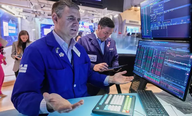 Specialist Thomas Schreck, foreground, works at his post on the floor of the New York Stock Exchange, Wednesday, Nov. 5, 2025. (AP Photo/Richard Drew)