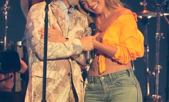 Marco Antonio Solis, left, and Karol G are seen after performing during the 2025 Latin Grammys on Thursday, Nov. 13, 2025, at MGM Grand in Las Vegas. (AP Photo/Chris Pizzello)
