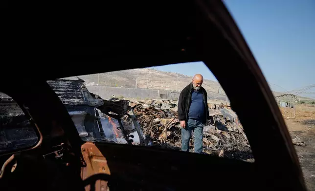 Mohammad Dalal looks at scorched cars in his scrapyard that was set ablaze the night before by who local residents alleged were Israeli settlers in the town of Huwara near the West Bank city of Nablus, Friday, Nov. 21, 2025. (AP Photo/Nasser Nasser)