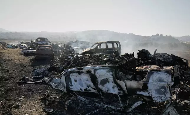 Smoke rises from scorched cars in a scrapyard that was set ablaze the night before by who local residents alleged were Israeli settlers in the town of Huwara near the West Bank city of Nablus, Friday, Nov. 21, 2025. (AP Photo/Nasser Nasser)