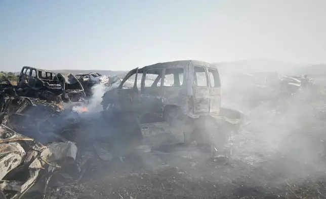 Smoke rises from scorched cars in a scrapyard that was set ablaze the night before by who local residents alleged were Israeli settlers in the town of Huwara near the West Bank city of Nablus, Friday, Nov. 21, 2025. (AP Photo/Nasser Nasser)