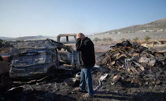 Mohammad Dalal looks at scorched cars in his scrapyard that was set ablaze the night before by who local residents alleged were Israeli settlers in the town of Huwara near the West Bank city of Nablus, Friday, Nov. 21, 2025. (AP Photo/Nasser Nasser)