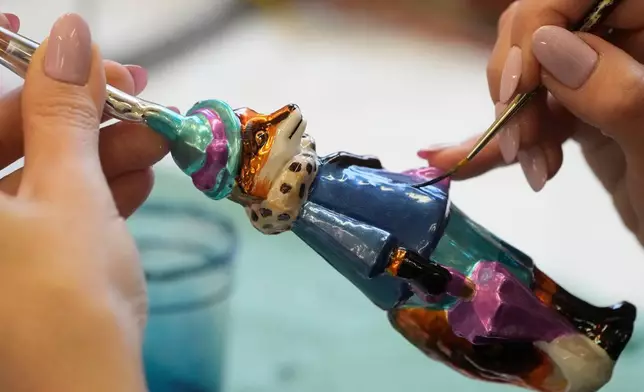 A worker prepares a hand-made Christmas bauble at GlitterLab in Czestochowa, southern Poland, on Nov. 21, 2025. (AP Photo/Czarek Sokolowski)
