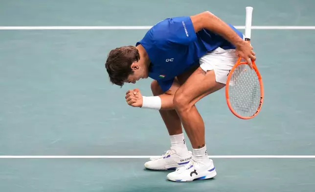 Italy's Flavio Cobolli celebrates after winning a point to Belgium's Zizou Bergs during a Davis Cup singles semifinal match between Italy and Belgium, in Bologna, Italy, Friday, Nov. 21, 2025. (AP Photo/Luca Bruno)