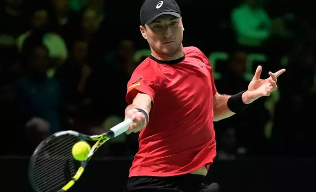 Belgium's Raphael Collignon returns a ball to Italy's Matteo Berrettini during a Davis Cup semifinal singles tennis match between Italy and Belgium, in Bologna, Italy, Friday, Nov. 21, 2025. (AP Photo/Luca Bruno)