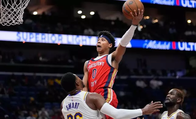 New Orleans Pelicans guard Jeremiah Fears (0) goes to the basket over Los Angeles Lakers guard Marcus Smart (36) in the first half of an NBA Cup basketball game, Friday, Nov. 14, 2025, in New Orleans. (AP Photo/Gerald Herbert)