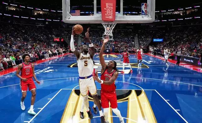 Los Angeles Lakers center Deandre Ayton (5) goes to the basket against New Orleans Pelicans forward Kevon Looney (55) in the first half of an NBA Cup basketball game, Friday, Nov. 14, 2025, in New Orleans. (AP Photo/Gerald Herbert)