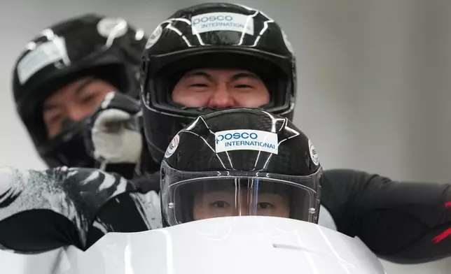 Kim Jinsu, Kim Sunwook, Kim Hyeonggeun and Lee Geonu, of South Korea, react as they finish their second run during the 4-man bobsleigh World Cup and Olympic test event in Cortina D'Ampezzo, Italy, Sunday, Nov. 23, 2025. (AP Photo/Andrew Medichini)