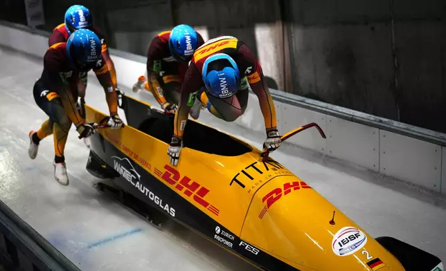 Johannes Lochner, Thorsten Margis, Joern Wenzel and Georg Fleischhauer, of Germany, start their first run during the 4-man bobsleigh World Cup and Olympic test event in Cortina D'Ampezzo, Italy, Sunday, Nov. 23, 2025. (AP Photo/Andrew Medichini)