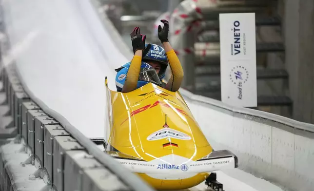 Laura Nolte and Deborah Levi, of Germany, celebrate when finishing their second run during the 2-woman bobsleigh World Cup and Olympic test event in Cortina D'Ampezzo, Italy, Sunday, Nov. 23, 2025. (AP Photo/Andrew Medichini)