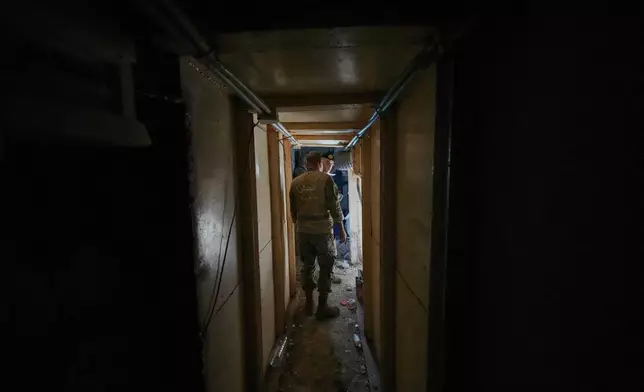 Lebanese army soldiers walk through a tunnel dug into a mountain that was used by Hezbollah militants as a clinic and storage facility, near the Lebanese-Israeli border in the Zibqin Valley, southern Lebanon, Friday, Nov. 28, 2025. (AP Photo/Bilal Hussein)
