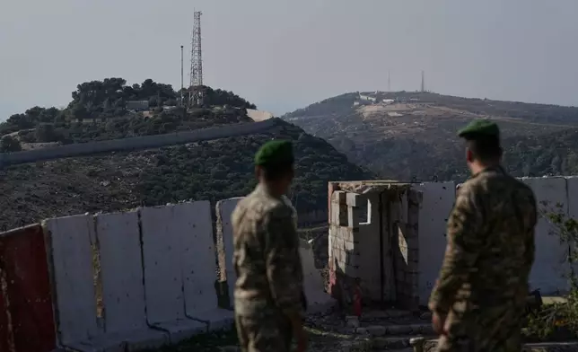 Lebanese army soldiers look at the Israeli military post of Hanita, left, and the Labbouneh post, one of five hills occupied by Israeli forces since last year, right, from a Lebanese military position in the village of Alma al-Shaab in south Lebanon, Friday, Nov. 28, 2025. (AP Photo/Bilal Hussein)