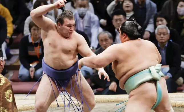 Ukrainian Aonishiki, left, fights with Kotozakura at the Kyushu Grand Sumo Tournament in Fukuoka, western Japan, Sunday, Nov. 23, 2025. (Kyodo News via AP)