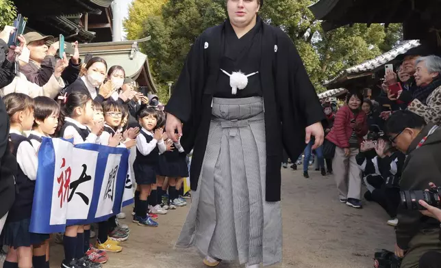 Ukrainian sumo wrestler Aonishiki, center, is celebrated by kindergarteners his promotion to the rank of ozeki in Kurume, Fukuoka prefecture, southern Japan Wednesday, Nov. 26, 2025. (Kyodo News via AP)