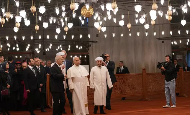 Pope Leo XIV, center, walking with Muezzin Musa Asgın Tunca, left, Dr. Emrullah Tuncel, second from left, and Imam of Mosque Sultanahmet Fatih Kaya, visits the Sultan Ahmed Mosque in Istanbul, Saturday, Nov. 29, 2025. (AP Photo/Domenico Stinellis)