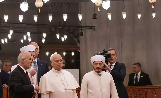 Pope Leo XIV, center, walking with Muezzin Musa Asgın Tunca, left, Dr. Emrullah Tuncel, second from left, and Imam of Mosque Sultanahmet Fatih Kaya, visits the Sultan Ahmed Mosque in Istanbul, Saturday, Nov. 29, 2025. (AP Photo/Domenico Stinellis)