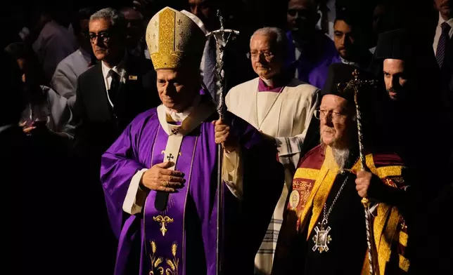 Pope Leo XIV arrives with Ecumenical Patriarch Bartholomew I, the spiritual leader of the world's Eastern Orthodox Christians to celebrate a Mass at the Volkswagen Arena, in Istanbul, Turkey, Saturday, Nov. 29, 2025. (AP Photo/Khalil Hamra)