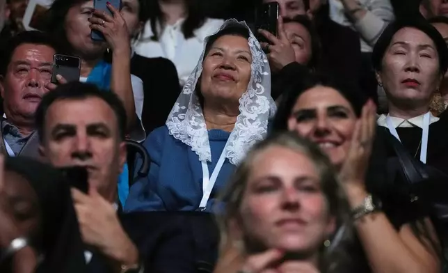 People attend a Mass celebrated by Pope Leo XIV at the Volkswagen Arena, in Istanbul, Turkey, Saturday, Nov. 29, 2025. (AP Photo/Dilara Acikgoz)