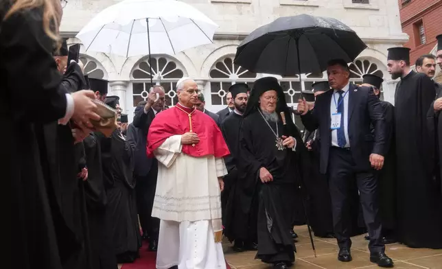 Pope Leo XIV and Ecumenical Patriarch Bartholomew I, the spiritual leader of the world's Eastern Orthodox Christians leave after a doxology service at the Patriarchal Church of Saint George, in Istanbul, Turkey, Saturday, Nov. 29, 2025. (AP Photo/Francisco Seco)