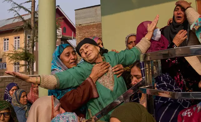 Relatives of Mohammad Shafi Parray, a Kashmiri civilian who was killed when a cache of confiscated explosives detonated inside a police station, mourn as they wait for his body outside his residence in Srinagar, Indian controlled Kashmir, Saturday, Nov. 15, 2025. (AP Photo/Dar Yasin)