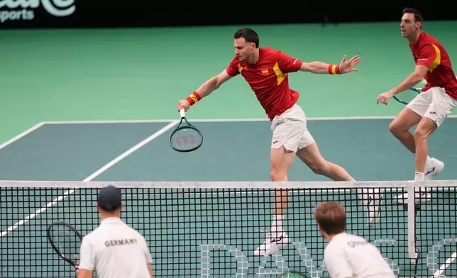 Spain's Pedro Martinez, top left, returns the ball with his teammate Marcel Granollers during a Davis Cup double semifinal tennis match against Germany's Kevin Krawietz and Tim Puetz, in Bologna, Italy, Saturday, Nov. 22, 2025. (AP Photo/Luca Bruno)