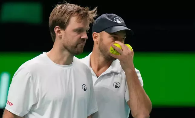 Germany's Kevin Krawietz, left, and Tim Puetz talk during a Davis Cup double semifinal tennis match against Spain's Marcel Granollers and Pedro Martinez, in Bologna, Italy, Saturday, Nov. 22, 2025. (AP Photo/Luca Bruno)