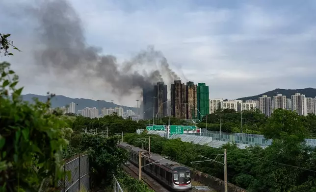 Smoke rises after a fire broke out at Wang Fuk Court, a residential estate in the Tai Po district of Hong Kong's New Territories, Thursday, Nov. 27 2025. (AP Photo/Chan Long Hei)