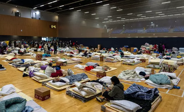 Residents rest at a temporary shelter near the fire scene at Wang Fuk Court, a residential estate in the Tai Po district of Hong Kong's New Territories, Thursday, Nov. 27, 2025. (AP Photo/Chan Long Hei)