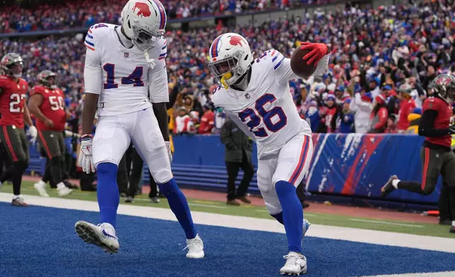 Buffalo Bills running back Ty Johnson (26) celebrates with wide receiver Tyrell Shavers (14) after scoring a touchdown against the Tampa Bay Buccaneers during the first half of an NFL football game, Sunday, Nov. 16, 2025, in Orchard Park, N.Y. (AP Photo/Carolyn Kaster)