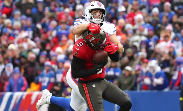 Tampa Bay Buccaneers linebacker SirVocea Dennis (8) intercepts the ball against Buffalo Bills tight end Dawson Knox, top, during the first half of an NFL football game, Sunday, Nov. 16, 2025, in Orchard Park, N.Y. (AP Photo/Jeffrey T. Barnes)