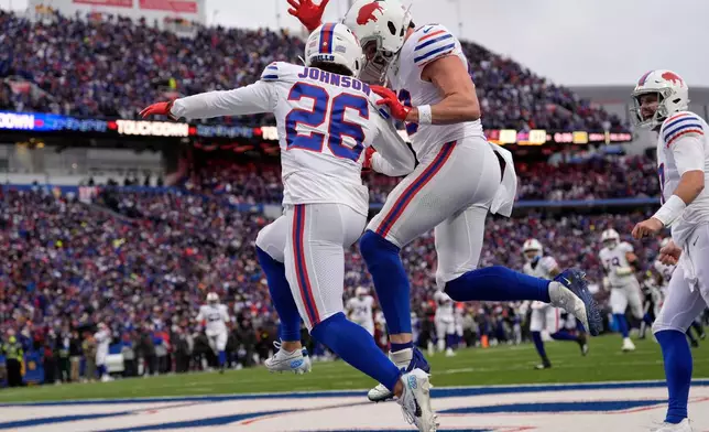 Buffalo Bills running back Ty Johnson (26) celebrates with tight end Dawson Knox, second from left, after scoring a touchdown against the Tampa Bay Buccaneers during the first half of an NFL football game, Sunday, Nov. 16, 2025, in Orchard Park, N.Y. (AP Photo/Carolyn Kaster)
