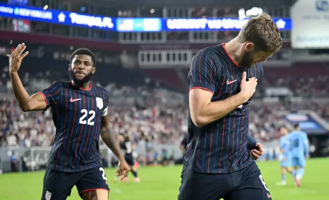 United States' Mark McKenzie (22) and Tanner Tessman celebrate Tessmann's goal during the second half of an international friendly soccer game against Uruguay, Tuesday, Nov. 18, 2025, in Tampa, Fla. (AP Photo/Jason Behnken)