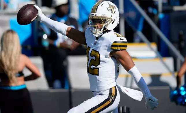 New Orleans Saints wide receiver Chris Olave celebrates after scoring against the Carolina Panthers during the first half of an NFL football game, Sunday, Nov. 9, 2025, in Charlotte, N.C. (AP Photo/Jacob Kupferman)