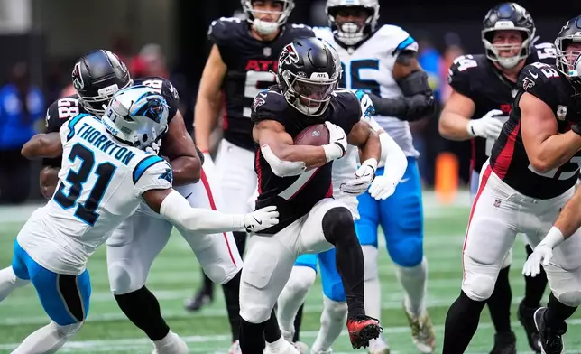 Atlanta Falcons running back Bijan Robinson (7) carries against Carolina Panthers cornerback Corey Thornton (31) in the first half of an NFL football game, Sunday, Nov. 16, 2025, in Atlanta. (AP Photo/Mike Stewart)