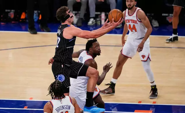 Orlando Magic's Franz Wagner (22) drives past New York Knicks' Og Anunoby (8) and Jalen Brunson (11) during the second half of an NBA basketball game Wednesday, Nov. 12, 2025, in New York. (AP Photo/Frank Franklin II)