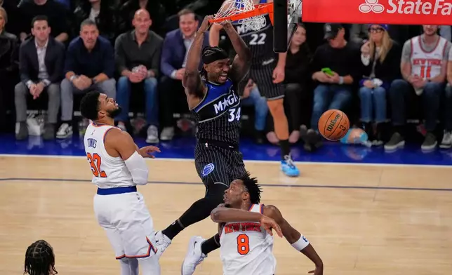 Orlando Magic's Wendell Carter Jr. (34) dunks the ball in front of New York Knicks' Karl-Anthony Towns (32) and Og Anunoby (8) during the second half of an NBA basketball game Wednesday, Nov. 12, 2025, in New York. (AP Photo/Frank Franklin II)