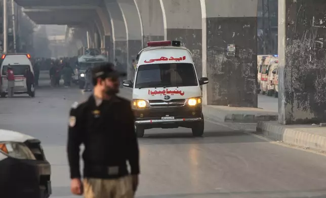 An ambulance carrying injured people drive towards a hospital after suicide bombers attacked the headquarters of the Federal Constabulary (FC), in Peshawar, Pakistan, Monday, Nov. 24, 2025. (AP Photo/Muhammad Zubair)