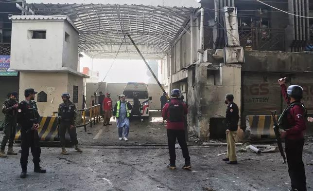 Security officials examine the site of a suicide bombing attack at the main gate of headquarters of the Federal Constabulary (FC), in Peshawar, Pakistan, Monday, Nov. 24, 2025. (AP Photo/Muhammad Zubair)